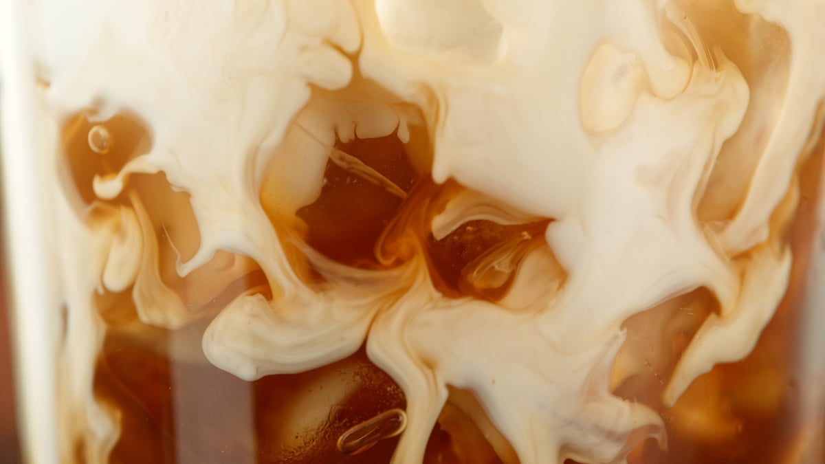 Pouring milk into freshly brewed coffee